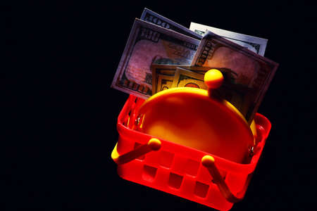 yellow purse money dollar plastic basket dark backgroundの写真素材