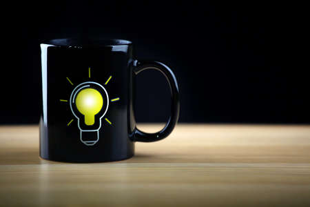 hot tea mug bulb symbol wooden table dark background nobody