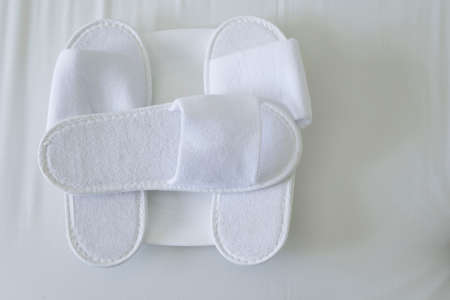 hotel bed with white slipper backgroundの写真素材