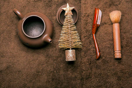 teapot brush wooden spoon gold miniature fir tree wool backgroundの写真素材
