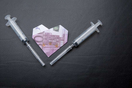 syringe money dark leather background