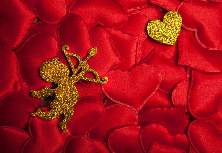gold cupid on red heart backgroundの写真素材