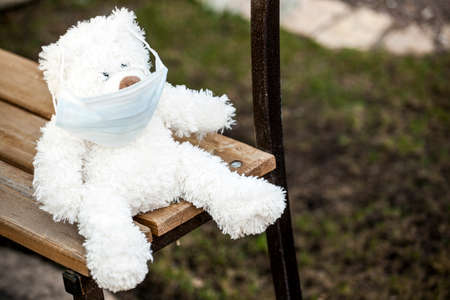 image of bear with mask sit on benchの写真素材