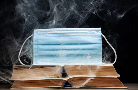 image of book mask smoke dark background