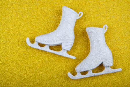 White glitter skates on yellow glitterの写真素材