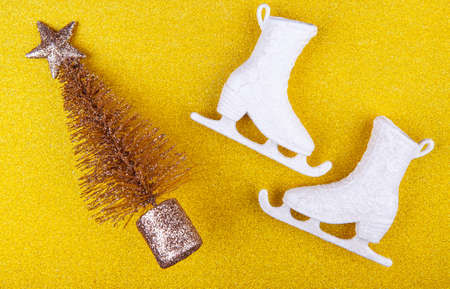 A pair of skates with Christmas tree on yellow glitterの写真素材