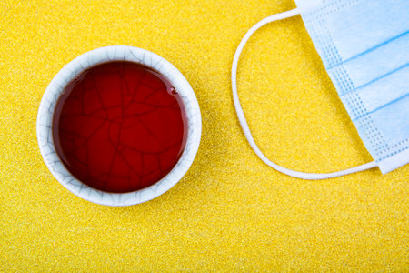 image of tea cup mask gold backgroundの写真素材