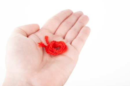 image of red thread hand white background