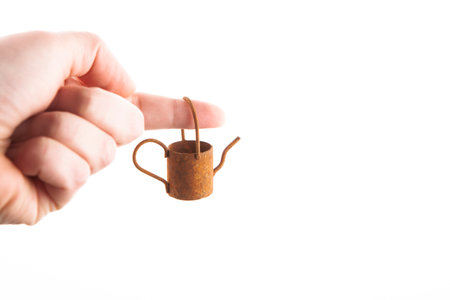 image of miniature rusty watering can hand white backgroundの写真素材