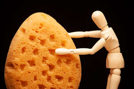 image of sponge wooden figure dark backgroundの写真素材