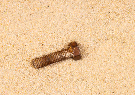 image of rusty bolt sand backgroundの写真素材