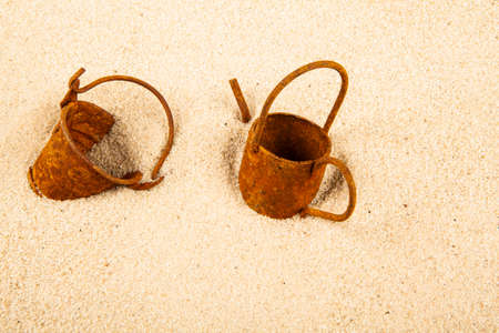 image of rusty watering can bucket sand background