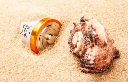 battery seashell sand background