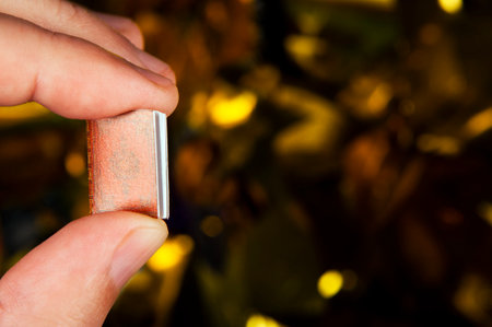 Man's hand holding a book against a background of golden confetti