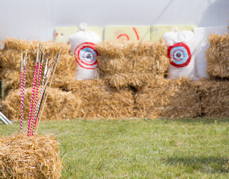 Archery targets and differernt colored arrows on rural shooting range outdoors on haystack background.の写真素材