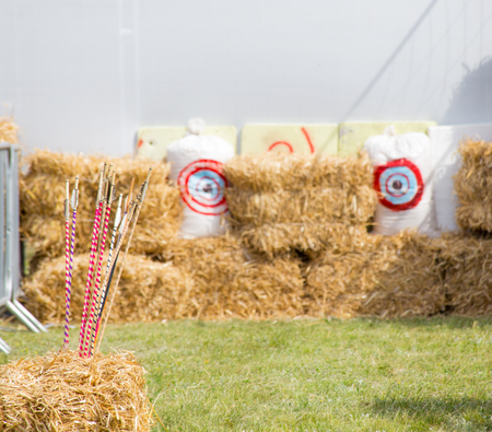 Archery targets and differernt colored arrows on rural shooting range outdoors on haystack...