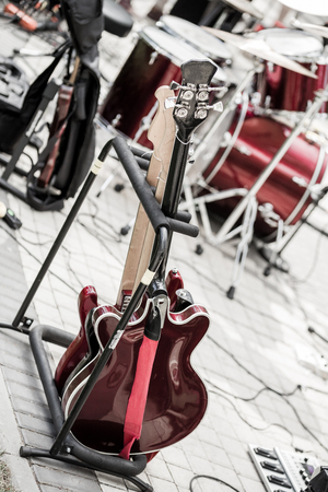 Two electric guitars a drums kit on a background in outdoor location.の写真素材