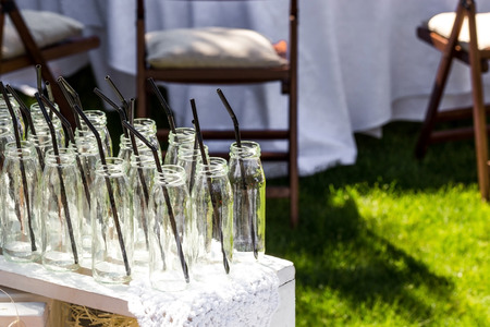 Small glass bottles with straws prepared for coctails at a party.の写真素材