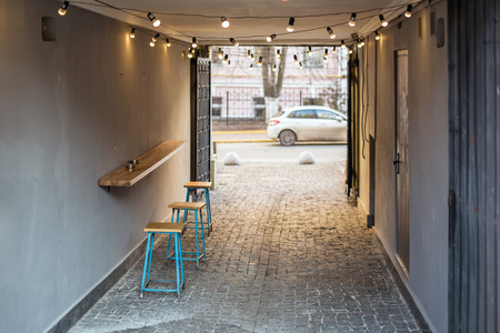 Backyard of old shabby building with one table cafe at the arc p