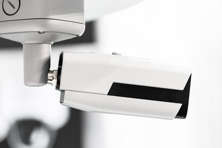 Big white professional surveillance camera.  CCTV mounted on ceiling. Security system concept. ...