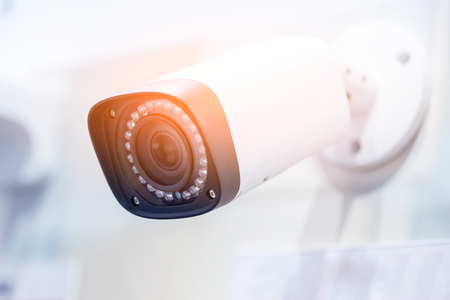 Big white professional surveillance camera.  CCTV mounted on ceiling. LED IR  lights around lens....