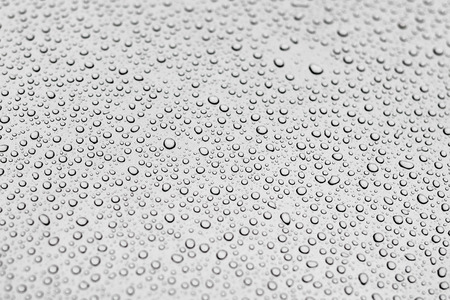 Texture of water drops on grey metal background. Small various drops with shadows on gray metalic paint. Flat view. Clear abstract water background with copyspace.の写真素材