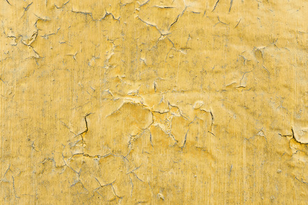Cracked toxic yellow paint texture. Close-up of old painted red wall. Abstract grunge background. Vintage scratched surface.の写真素材