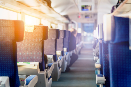 Interior of modern intercity express train. Back view of  wide comfortable seats in row at  railroad transport. Sunrise light through window.の写真素材