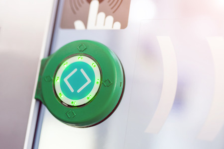 Green round touch button with arrows. Transparent door between carriages in intercity train. 