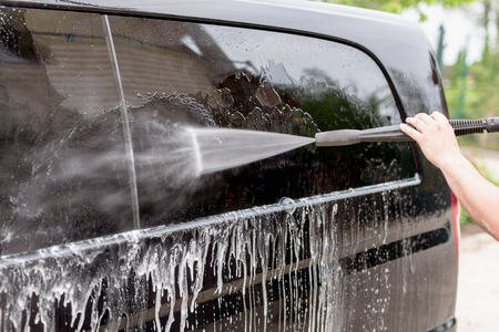 Manual car wash. Washing luxury vehicle with high pressure water pump.Automobile  cleaning self serviceの写真素材
