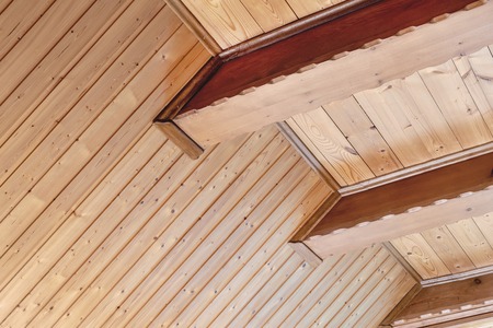Rustic house ceiling with wide wooden beam support. Country home interior. Building natural decoration materialsの写真素材