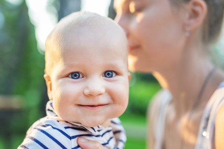 Mother and little son outdoors. Mom and baby boy having fun together in green garden or park. Happy family, child and parenthood conceptの写真素材