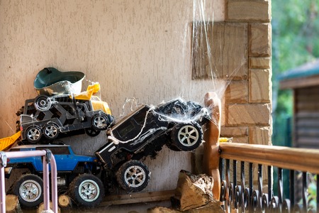 Abandoned and forgotten old toys covered with spider web stored at backyard. Grow up of child. Childhood end conceptの写真素材