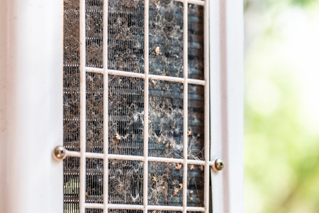 Close-up outdoor air condition unit with clogged obstructed compressor radiator grill. Details of air conditioner needed to clean and maintenance. House climate system check up and serviceの写真素材