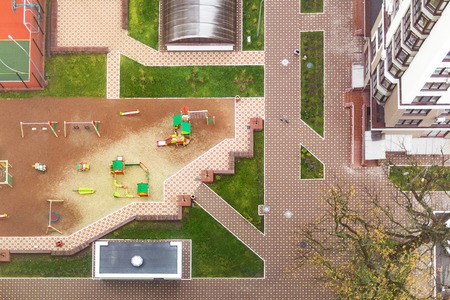Top view of inner yard of apartment building complex with children playground, sport area, green...