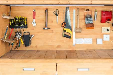 Wooden workbench at workshop. Lot of different tools for diy and repair works. Wood desk for product display. Copyspace. Labour day.の写真素材