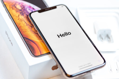 12th October,2018-Kiev,Ukraine: Latest Iphone XS on opened box on white table. Newest Apple smartphone on white branded box in mobile store. Edge frameless screen with loading Hello textのeditorial素材