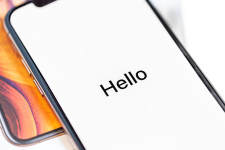 12th October,2018-Kiev,Ukraine: Latest Iphone XS on opened box on white table. Newest Apple smartphone on white branded box in mobile store. Edge frameless screen with loading Hello textのeditorial素材