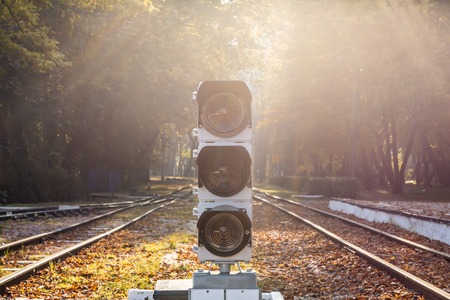 Railway traffic light with baclkight natural sun flare. Railroad station and semaphore in beautiful...