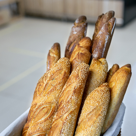 Traditional crusty French bread baguette in basket at bakery. Fresh organic pastry at local market. France cuisine background.の写真素材