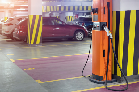 Electric car fast charging station at indoor underground parking. Power supply point network for hybrid electric car charging battery. Eco green energy.の写真素材