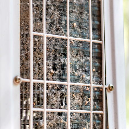 Close-up outdoor air condition unit with clogged obstructed compressor radiator grill. Details of air conditioner needed to clean and maintenance. House climate system check up and service.の写真素材