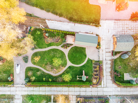 Aerial drone view of backyard garden with circle wath path, green grass lawn and trees. Landscape...