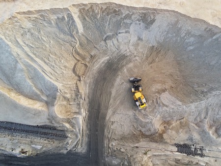 Big heavy wheel loader loading sand into dump truck in sand pit. Heavy industrial machinery concept.の写真素材