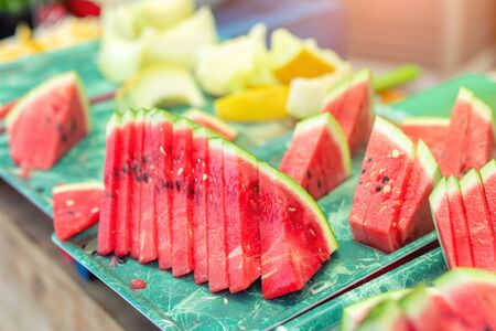 Fresh tasty juicy sliced watermelon and melon on tray outdoors.の写真素材