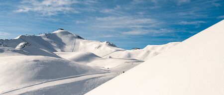 Scenic valley of hilghland alpine mountain winter resort on bright sunny day. Wintersport scene with...