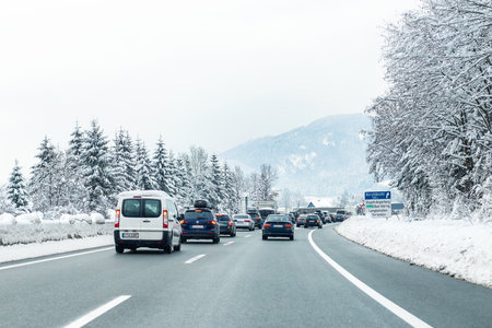 January 12th, 2019 - Salzburg, Austria: Winter highway with many different cars stucked in traffic jam due ti bad weather conditions. Vehicles on road heavy snowstorm and blizzard on cold winter day.のeditorial素材