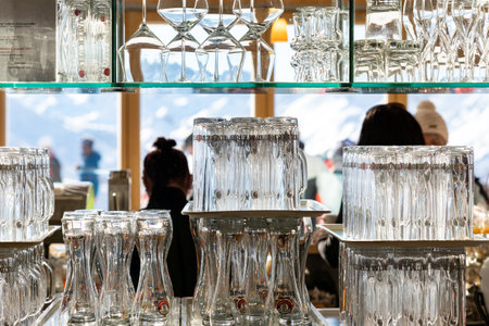 Ischgl,Austria - January 10th, 2020: Wall of many empty transparent wine and beer glasses on glass shelf at mountain restaurant on Idalp area of Ischgl winter snow skiing resort. Apres ski res placeのeditorial素材