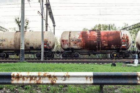 Old rusty tanker wagon at railway station. Freight industrial transportation liquid goods cistern.