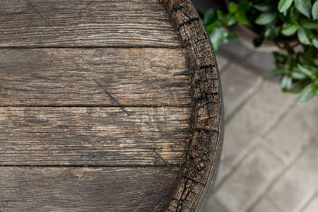 Close-up background of top of old retro vintage weathered wooden cask barrel. Wineyard, distillery, pub or bar table decoration and design. Copyspace abstract natural flat lay surface.の写真素材